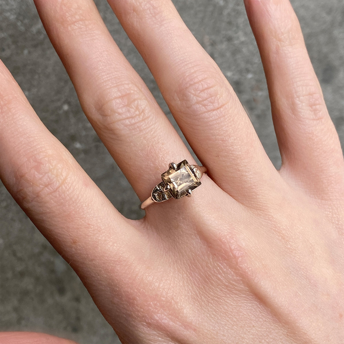 square smoky quartz stone on a silver band worn on the hand