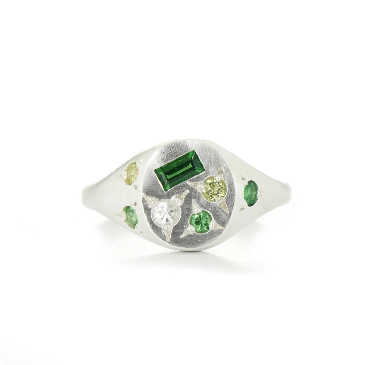 A silver signet ring featuring a rectangular green stone, surrounded by small green and yellow gemstones, set against a plain white background.