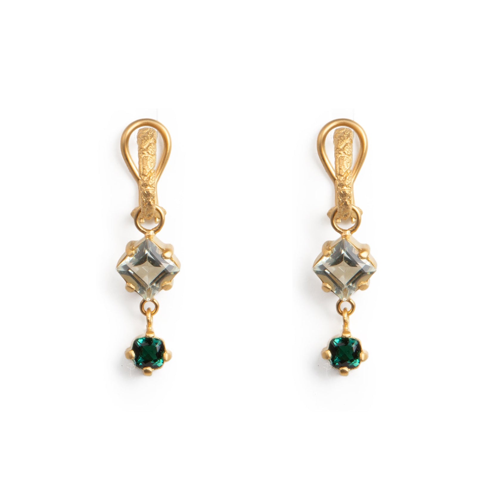 Gold earrings with green gemstones on a white background