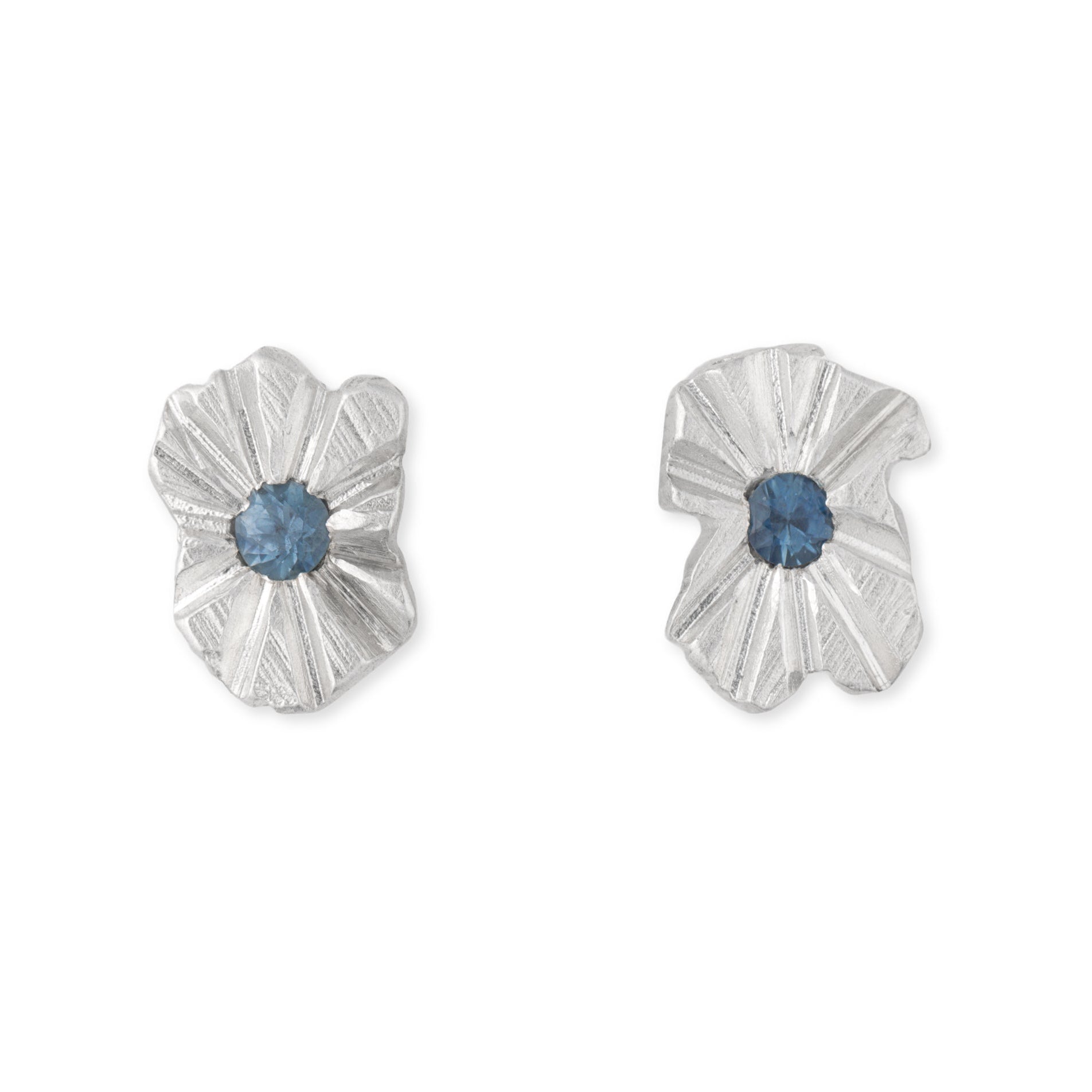 A pair of silver studs with blue sapphires in the centre