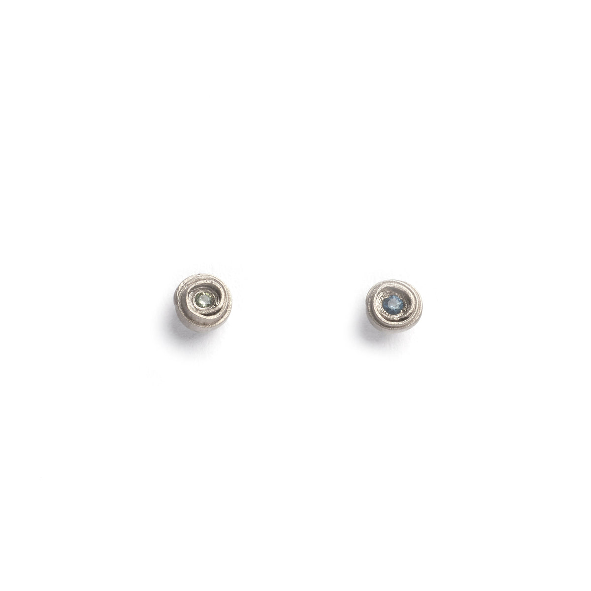 Silver coiled studs with blue and green stones on a white background