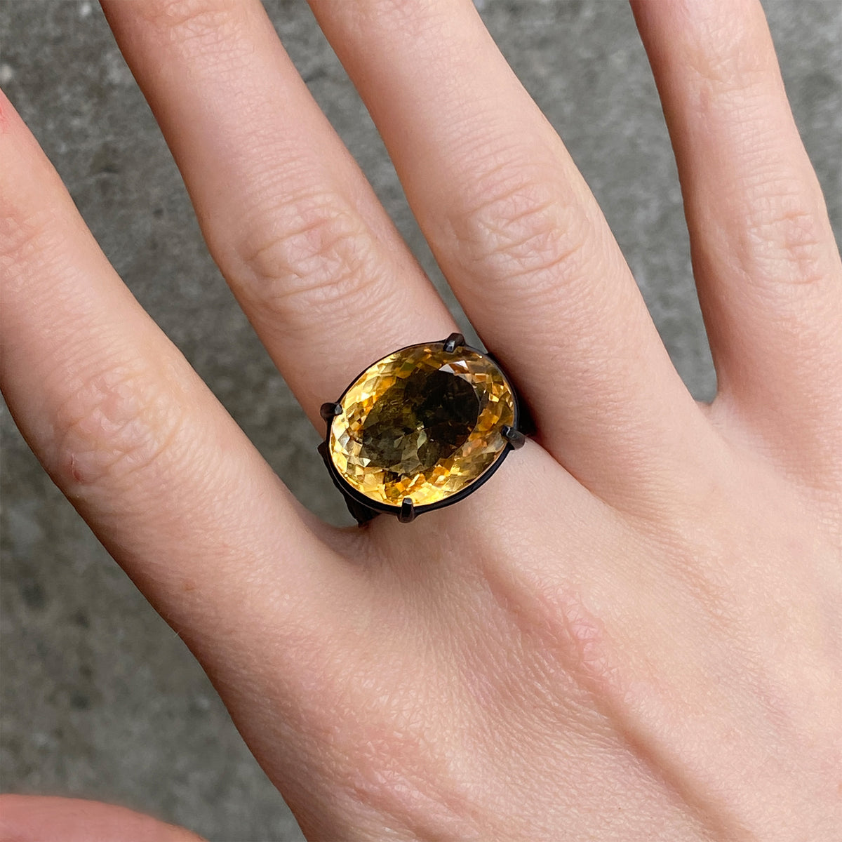 large oval citrine on a black band worn on hand 
