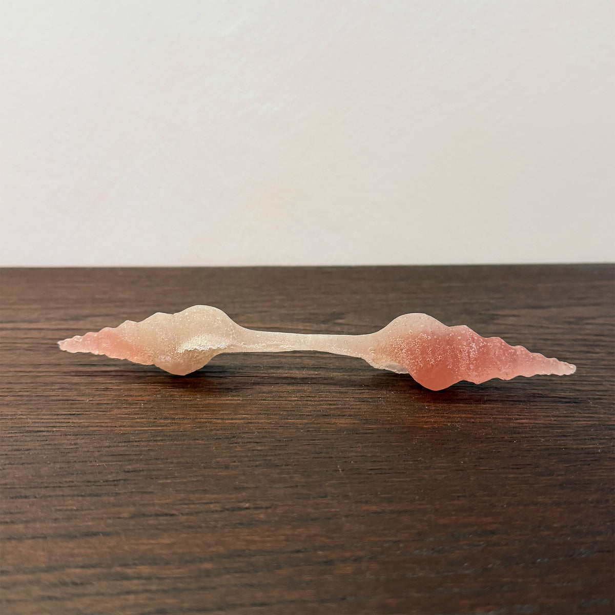 pink glass sculpture on a wooden table