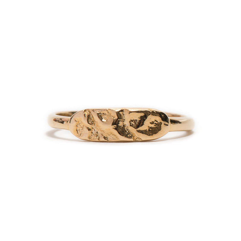 Gold ring with a textured design on a white background